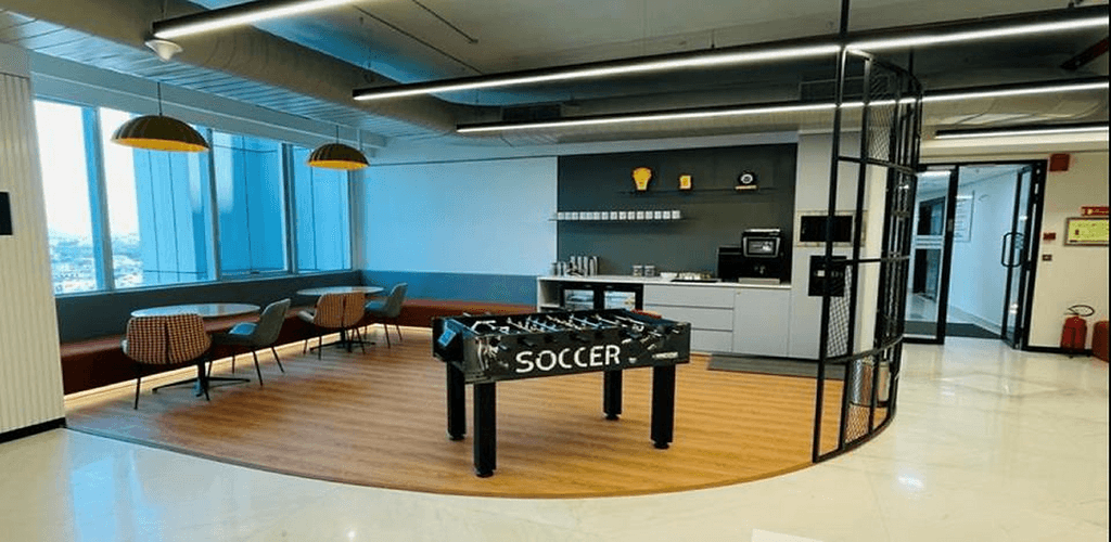 Vibrant Open Office floor with ergonomic desks, blue accents, and a communal meeting table in Boomi.