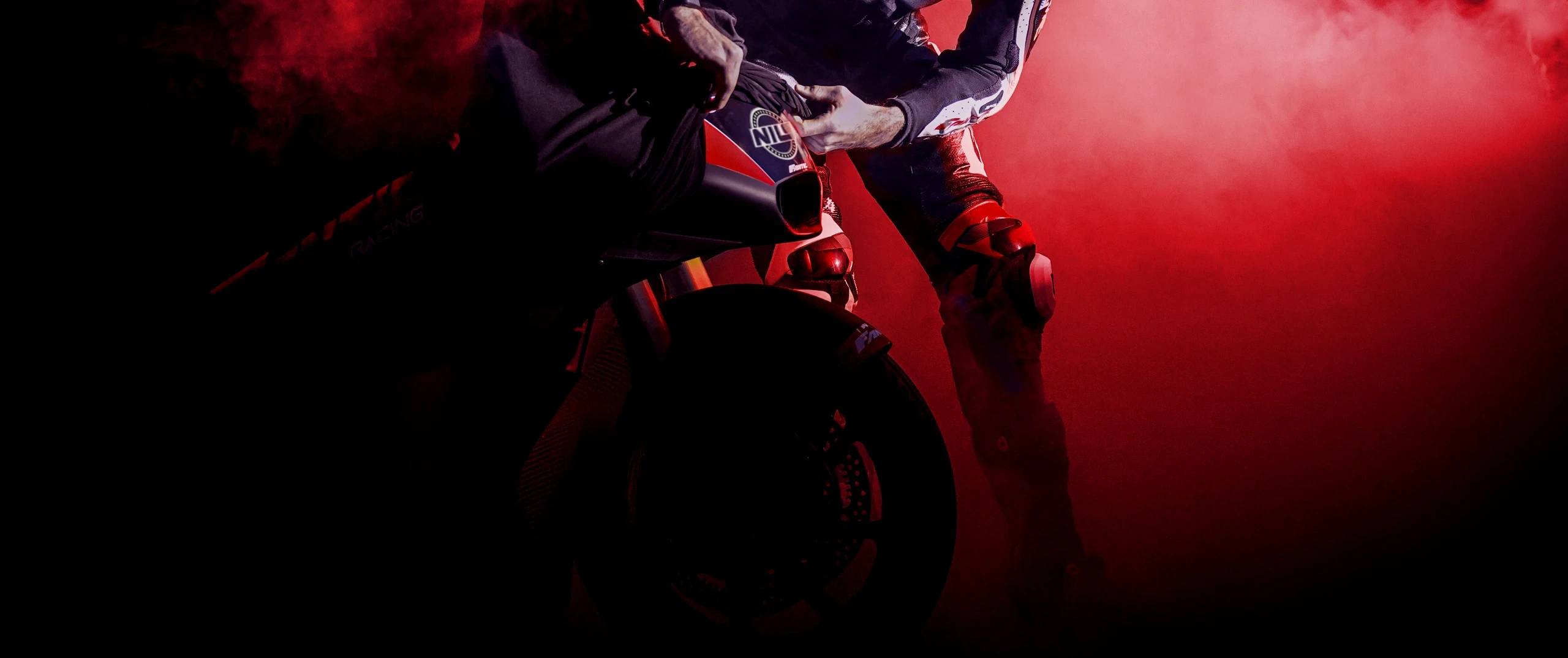 Primo piano della trasmissione di una moto con motore rosso lucidato, catena dorata e corona posteriore in un'officina