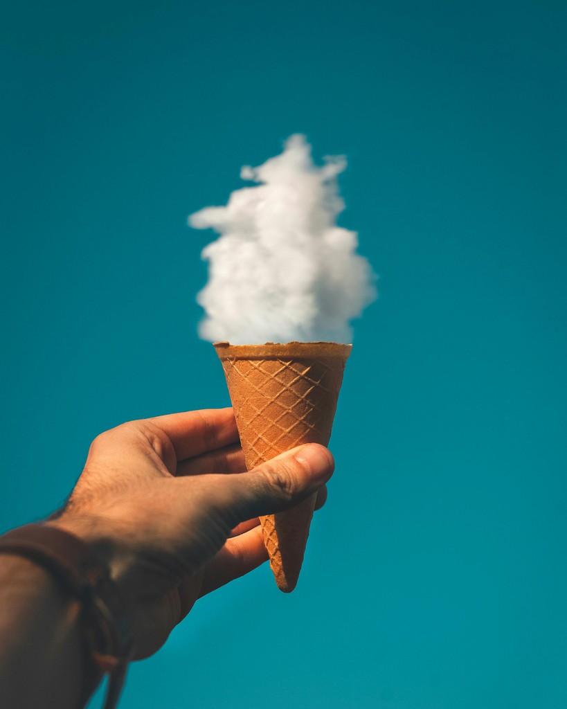 Image depicting a person holding the clouds in an ice cream cone