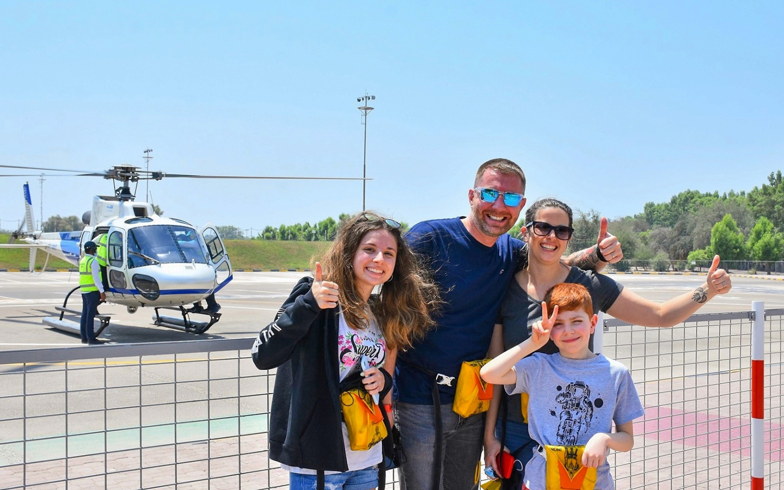 一家人在迪拜的一处直升机停机坪前与直升机合影。