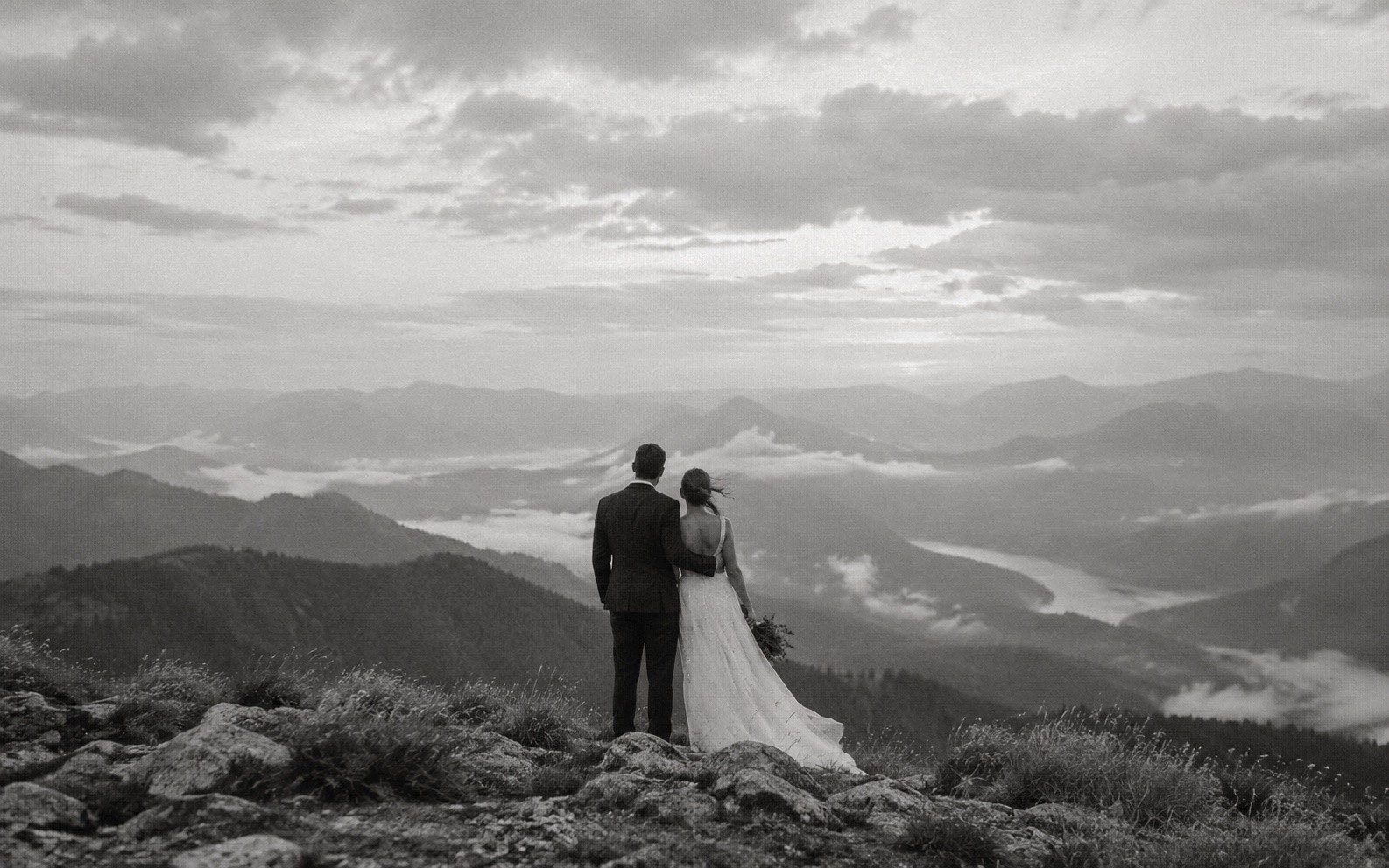 Newlyweds walking together through a mountain landscape