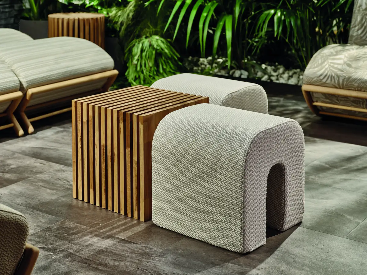 Refined contemporary outdoor poufs and sculptural wooden coffee table, featured at Salone del Mobile 2025 in Milan.