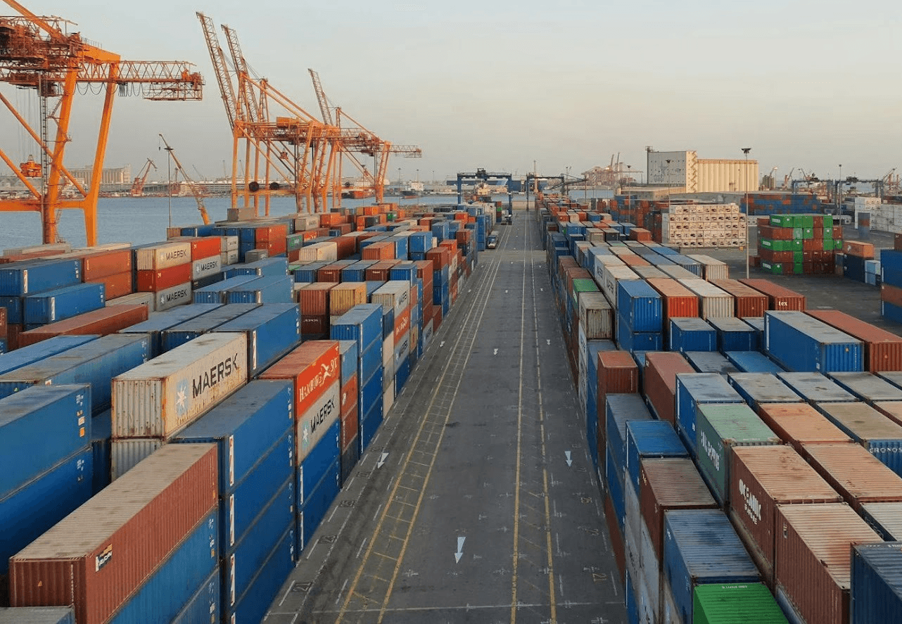 A bustling port scene with colorful cargo containers at sunrise. Ideal for logistics concepts.