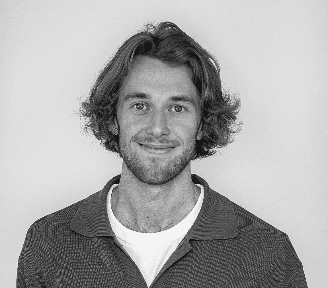 A portait of Lukas, he have a big smile, short beard and long blond hair.