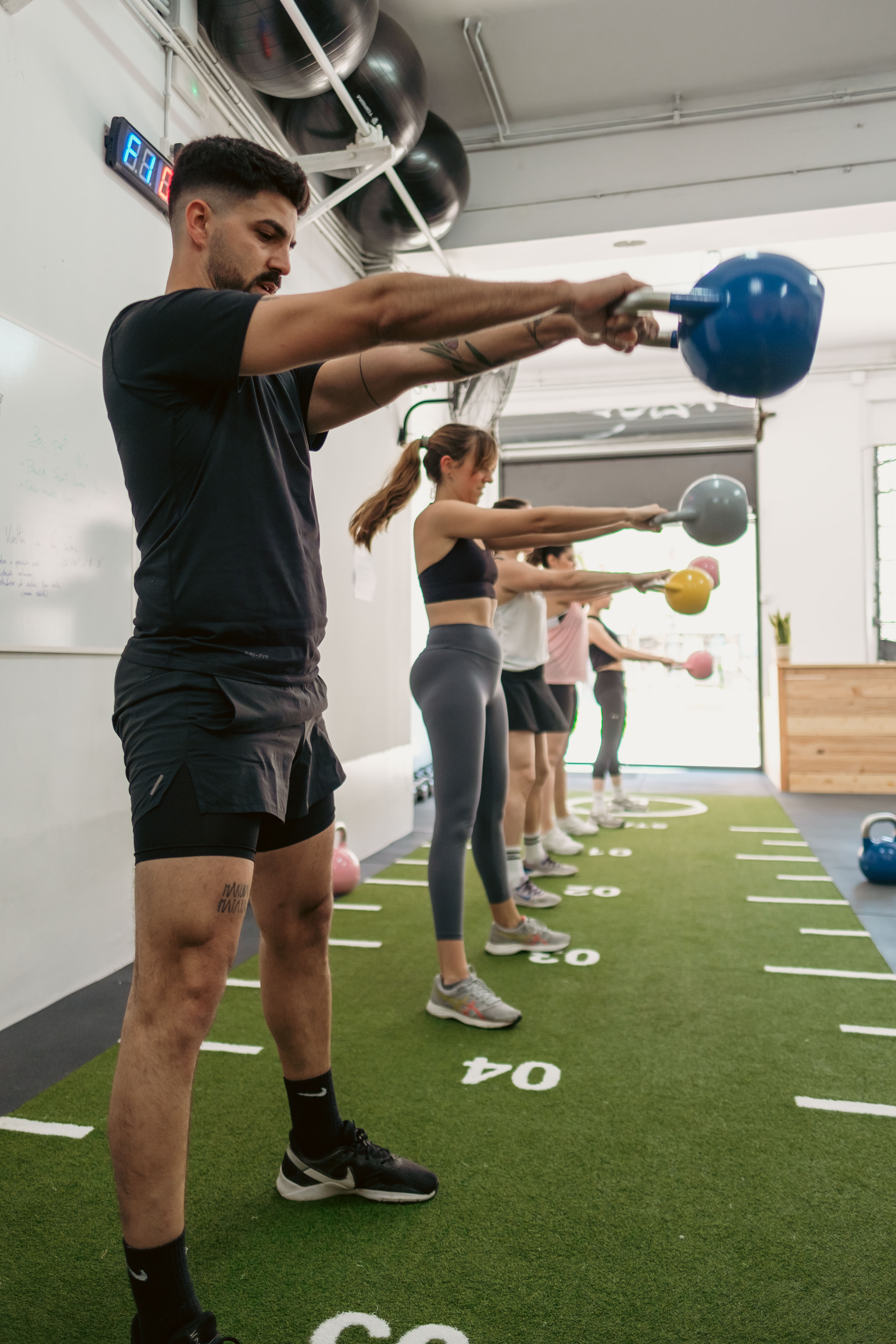 Participantes entrenando con kettlebells durante una sesión FIT ONE en One Life Training para mejorar la fuerza y la resistencia.