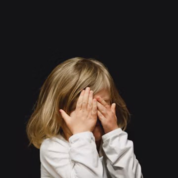 girl covering her face with both hands