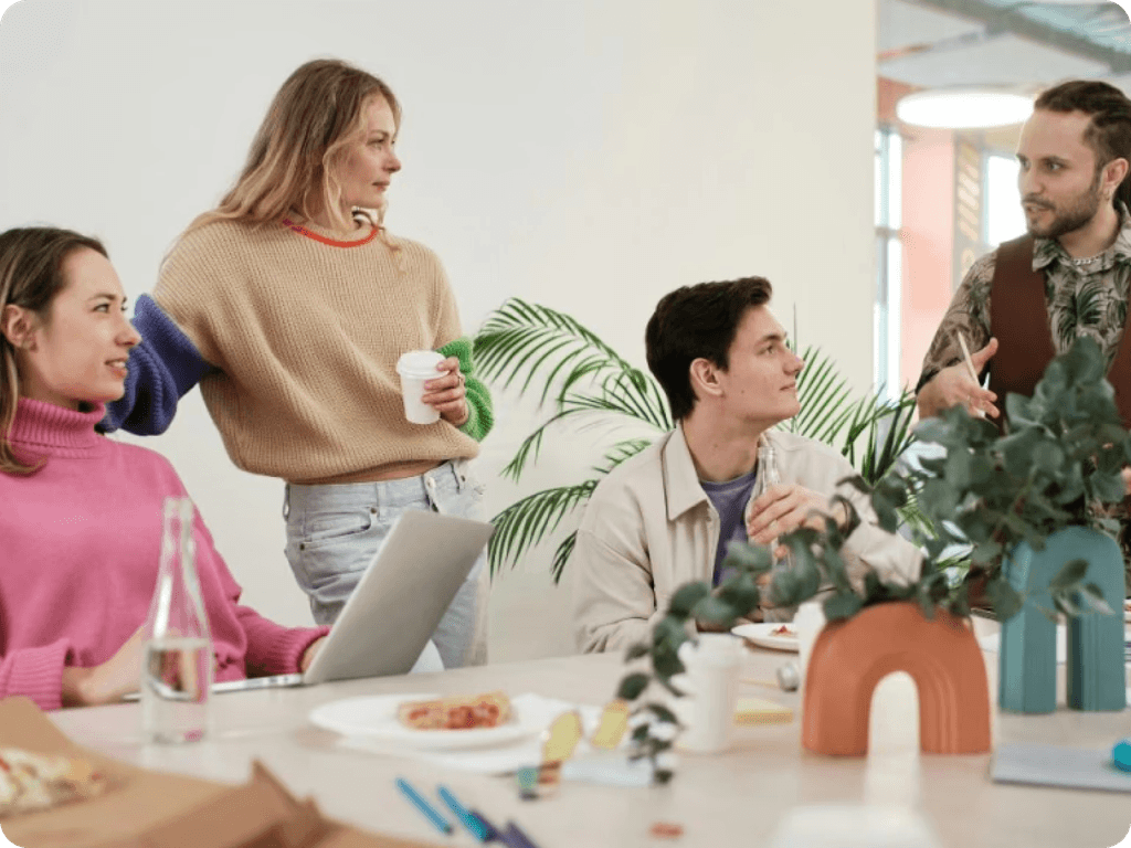 A diverse group of individuals gathered around a table, enjoying a delicious pizza together.