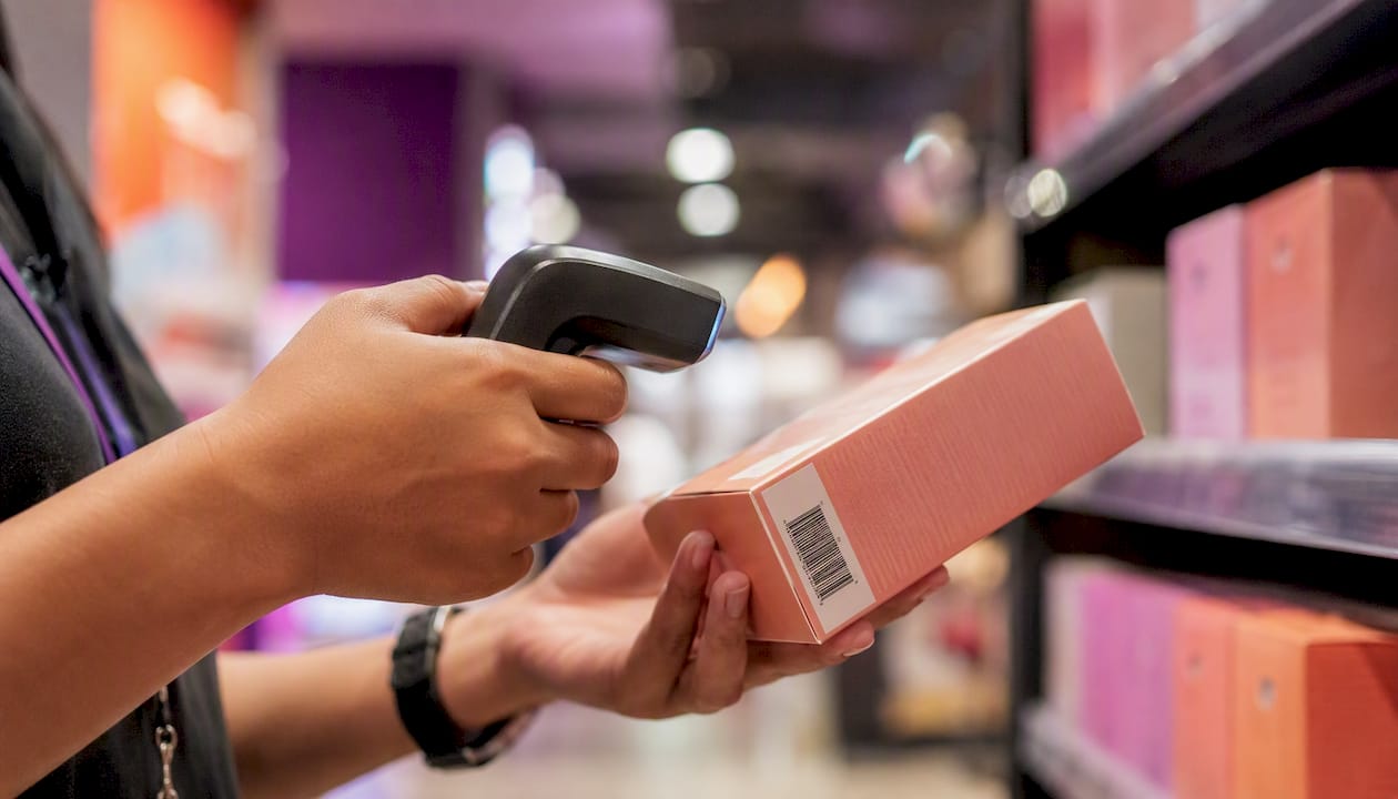 Hands scanning barcode on product in warehouse