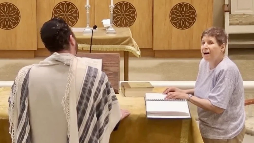 A JBI Library patron reads from the Torah using braille. Photo courtesy of JBI Library.