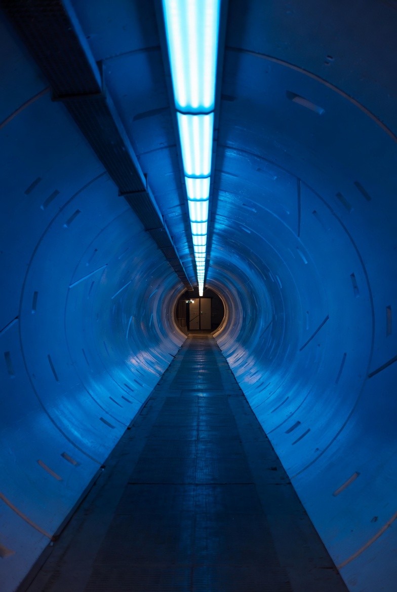 Illuminated tunnel with blue light at the end, representing the beginning of an AI transformation journey