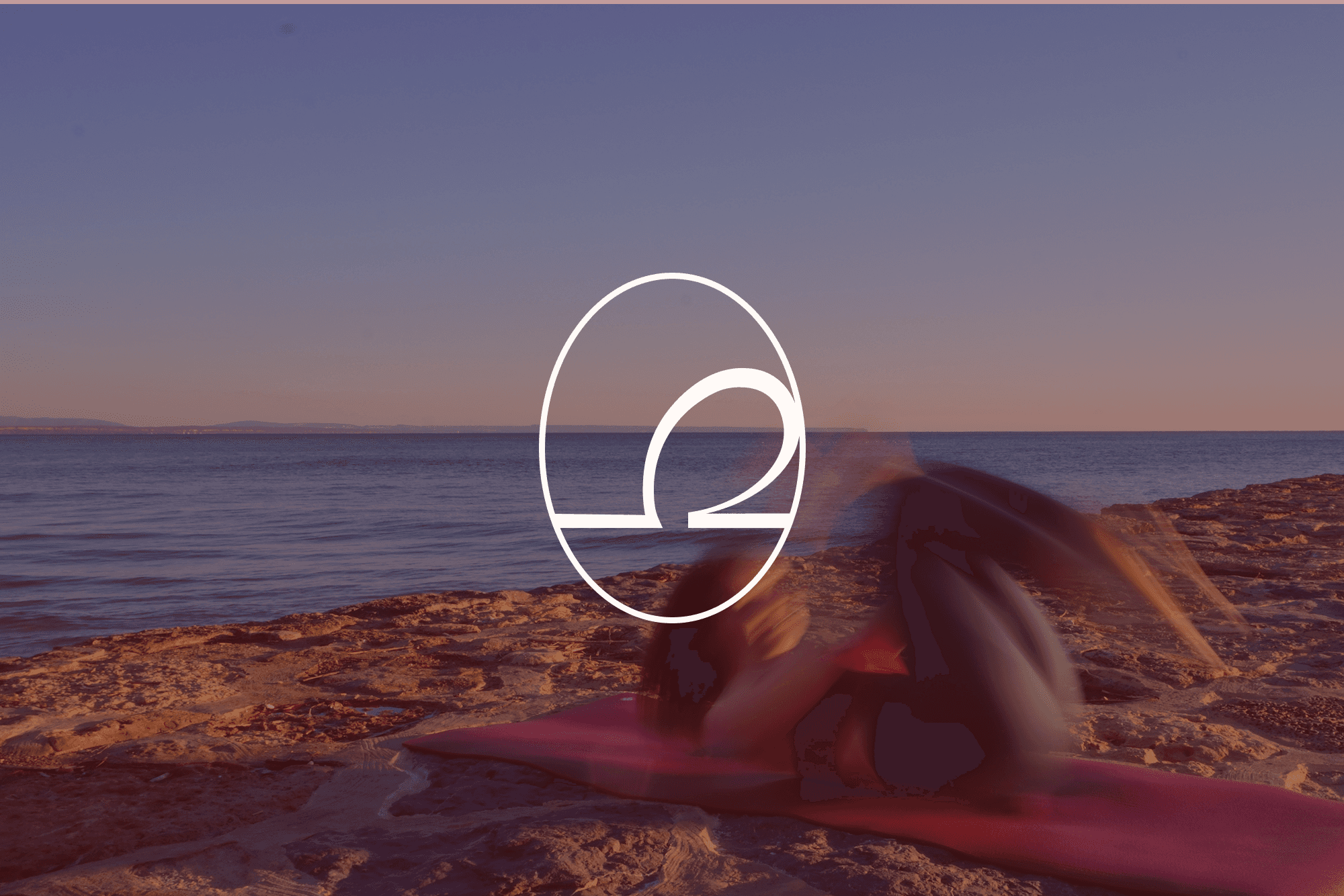 A woman at the beach lying on a pilates mat and rolling backwards.