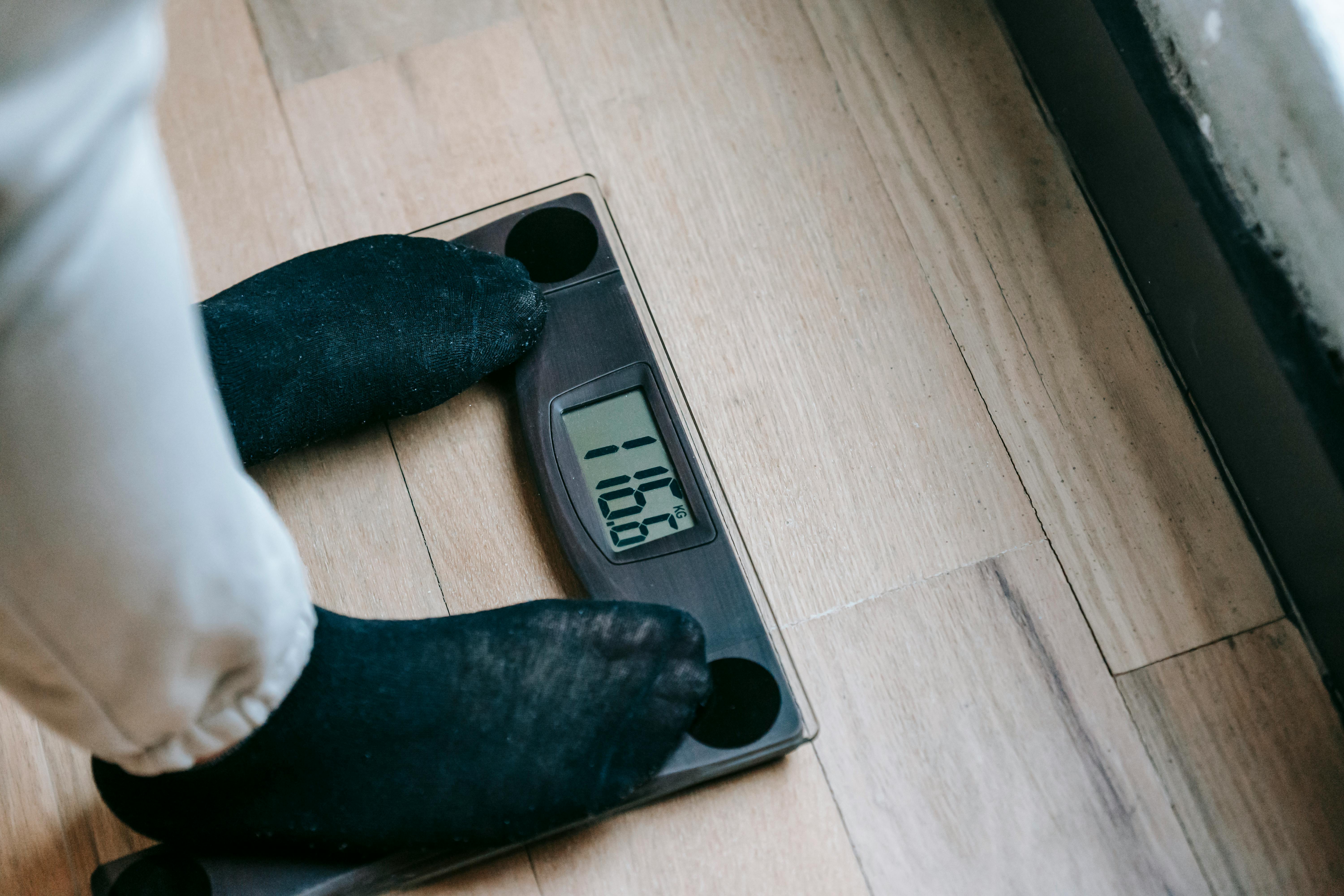 A man on a weighing scale to measure body mass