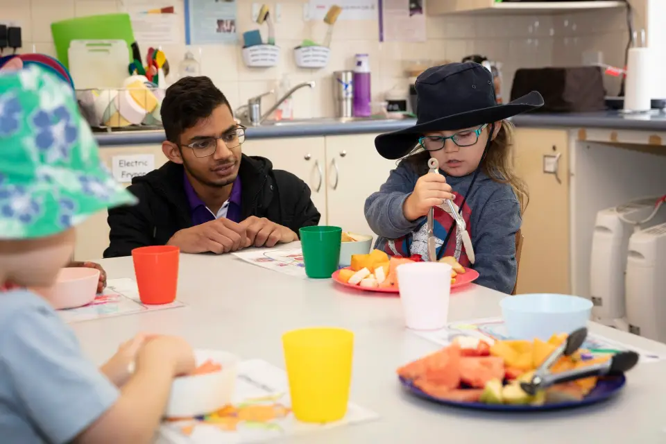 Educator and children painting together