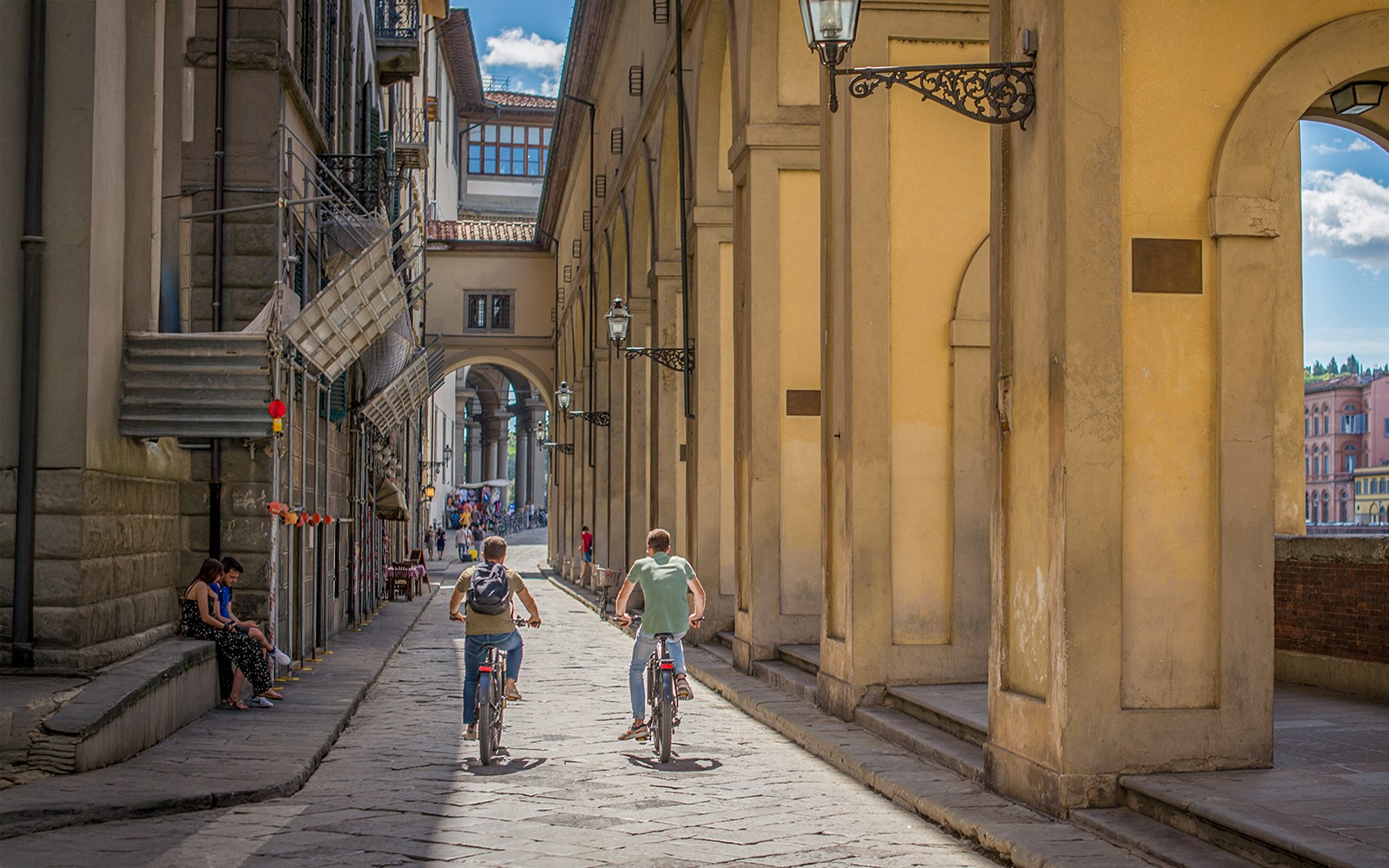 骑自行车的人在意大利佛罗伦萨的老桥附近骑行。