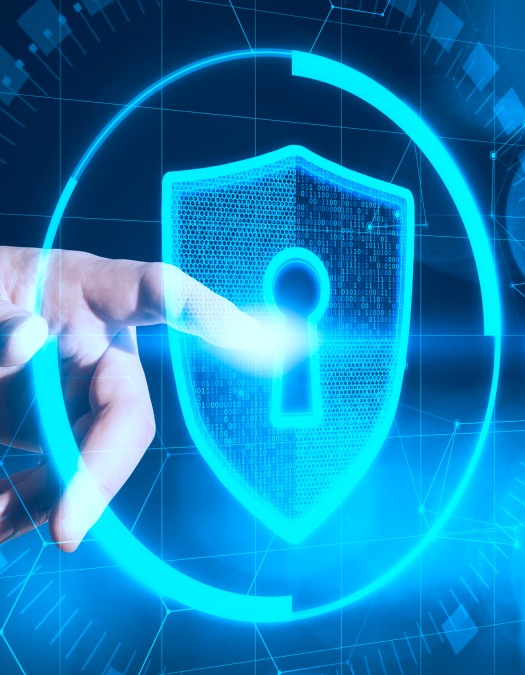 A hand interacting with a digital security shield interface representing cybersecurity.