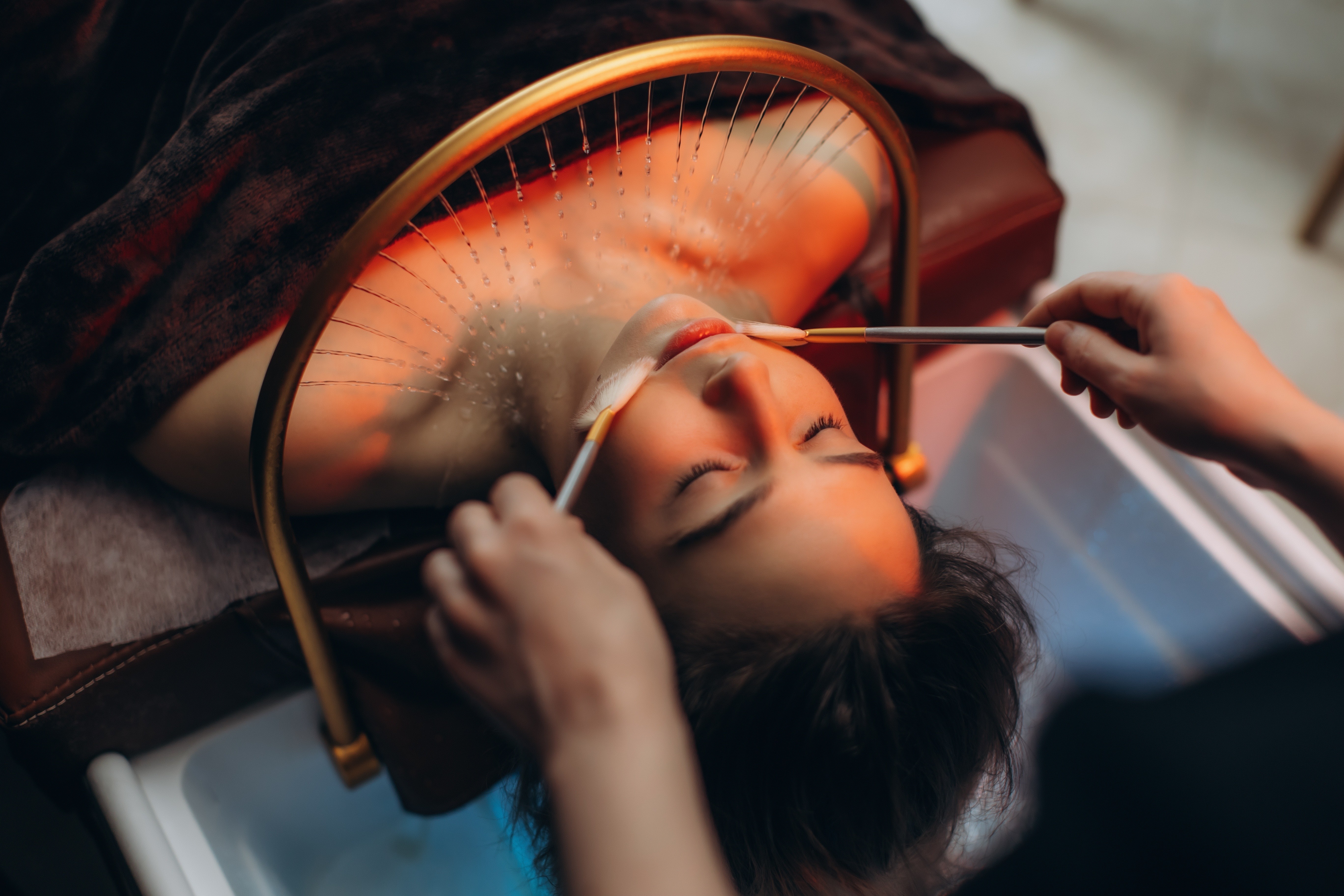 Client enjoying a Japanese-inspired head spa treatment with a warm water halo and relaxing facial care.