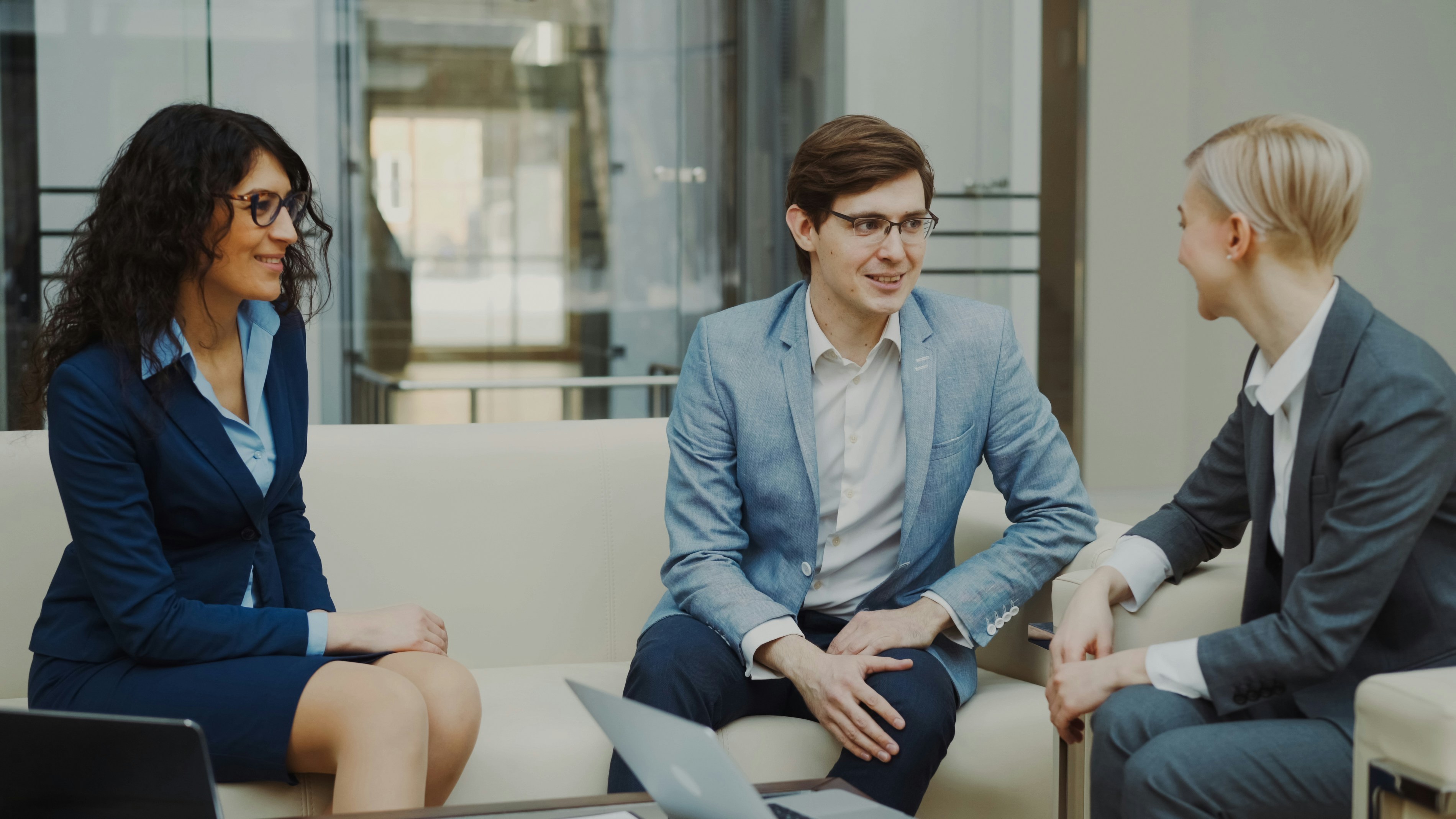 Three business people in a meeting on a couch.
