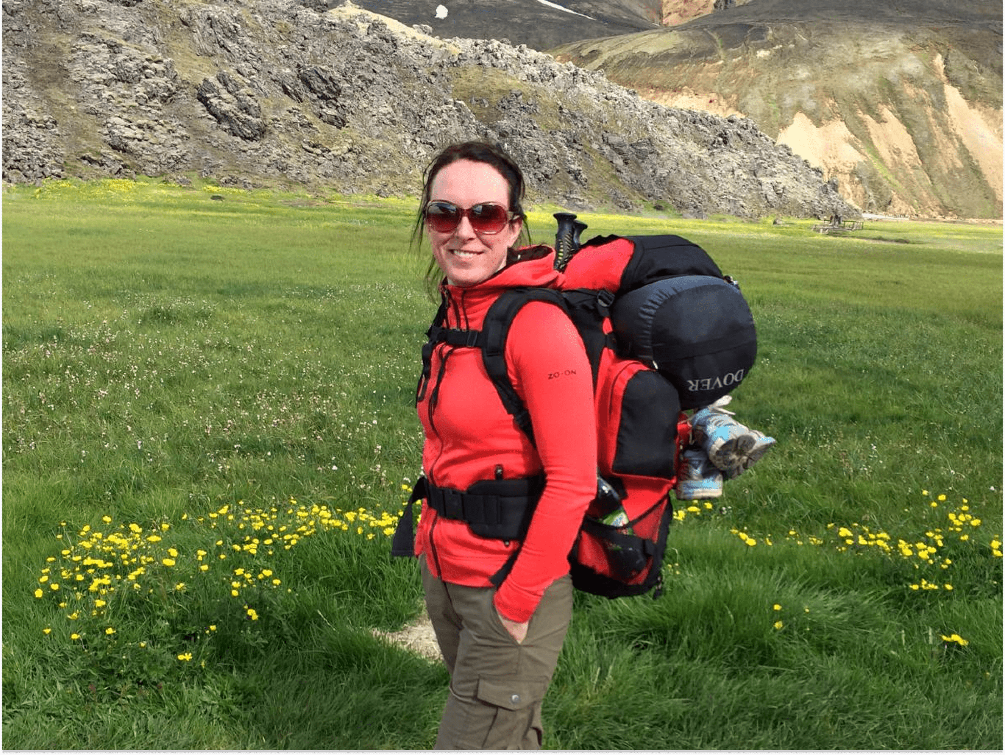 A woman in a red jacket and a backpack