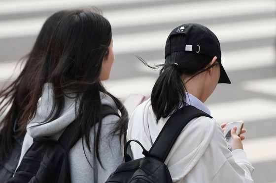 서울의 한 중학교에서 하교하는 학생들. 질병관리청의 2025년 청소년건강행태조사에 따르면 국내 청소년의 주중 스마트폰 사용 시간은 남학생 약 4.2시간, 여학생 약 4.9시간이다. 주말에는 남학생 6시간, 여학생 7시간을 넘긴다. 연합뉴스