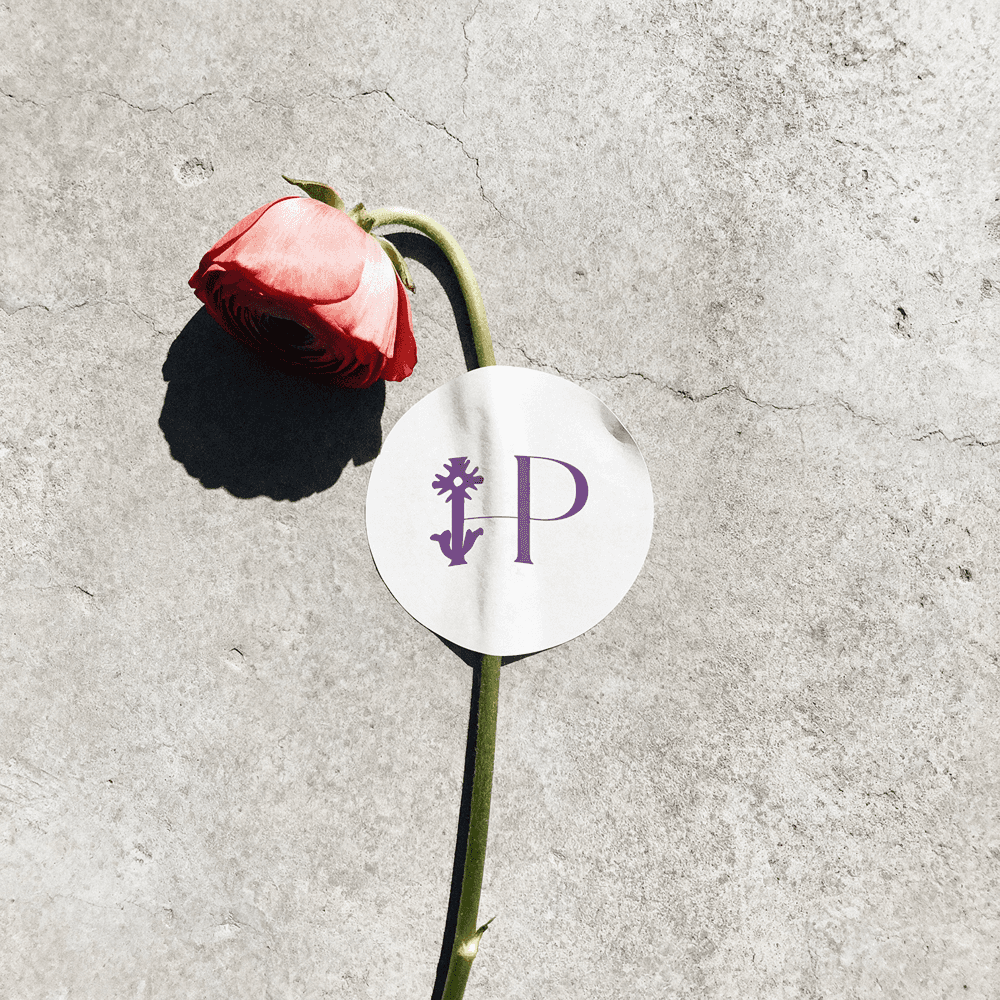 Circular logo application displayed on a textured tag, highlighting the brand’s romantic yet minimal mark.