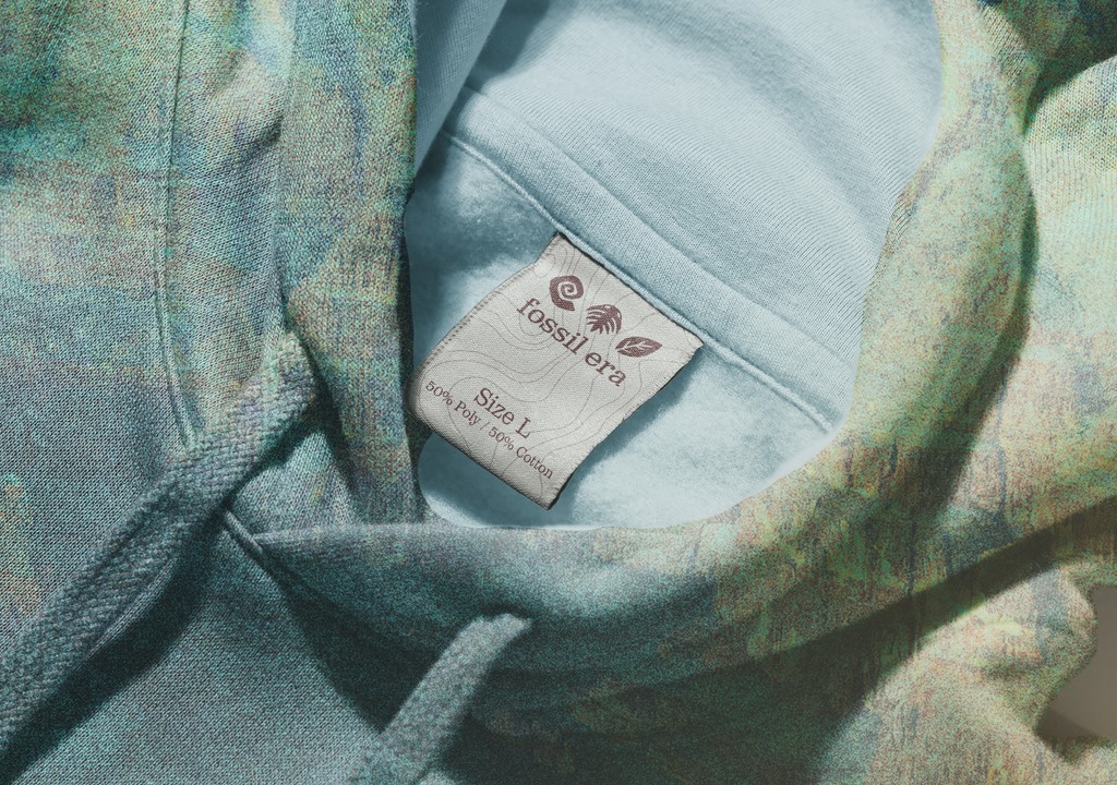 Light turqoise hoodie with a tag with the Fossil Era logo and icons.