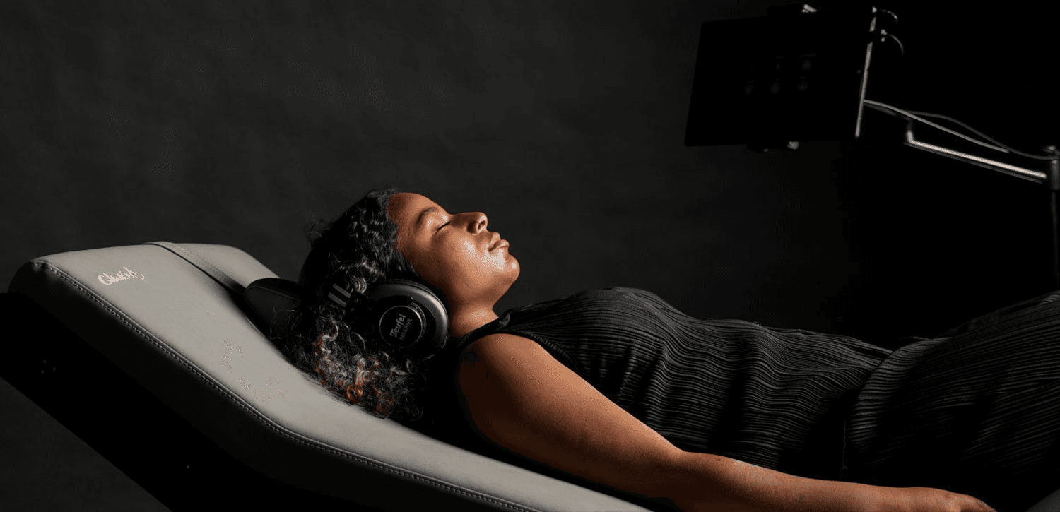 A close-up of hands performing a soothing massage on a client’s back, with warm golden light illuminating the skin. The scene evokes relaxation and well-being.