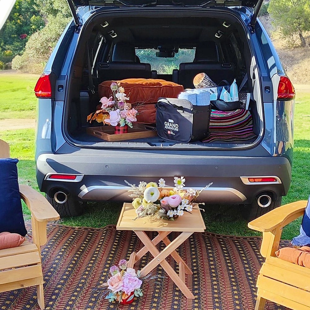A close-up of 2025 Toyota Grand Highlander's liftgate opened with a picnic set-up next to it.
