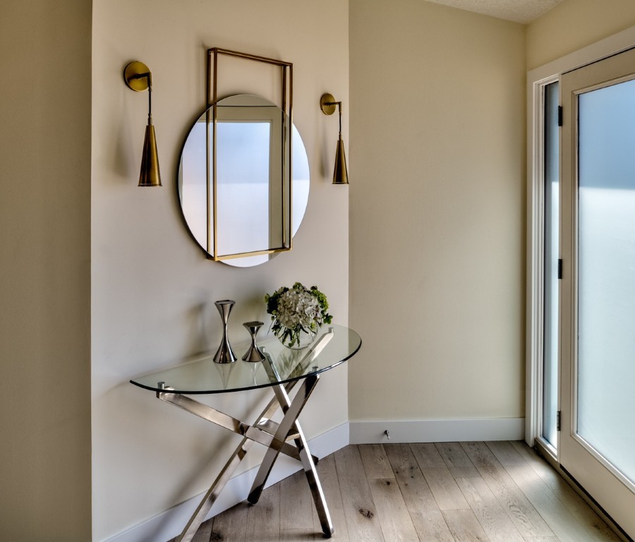 Image of Luxury interior design featuring a glass table, gold mirror, and sconces in a KHD Homes design-build project.