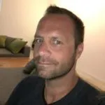 smiling woman wearing blue necklace