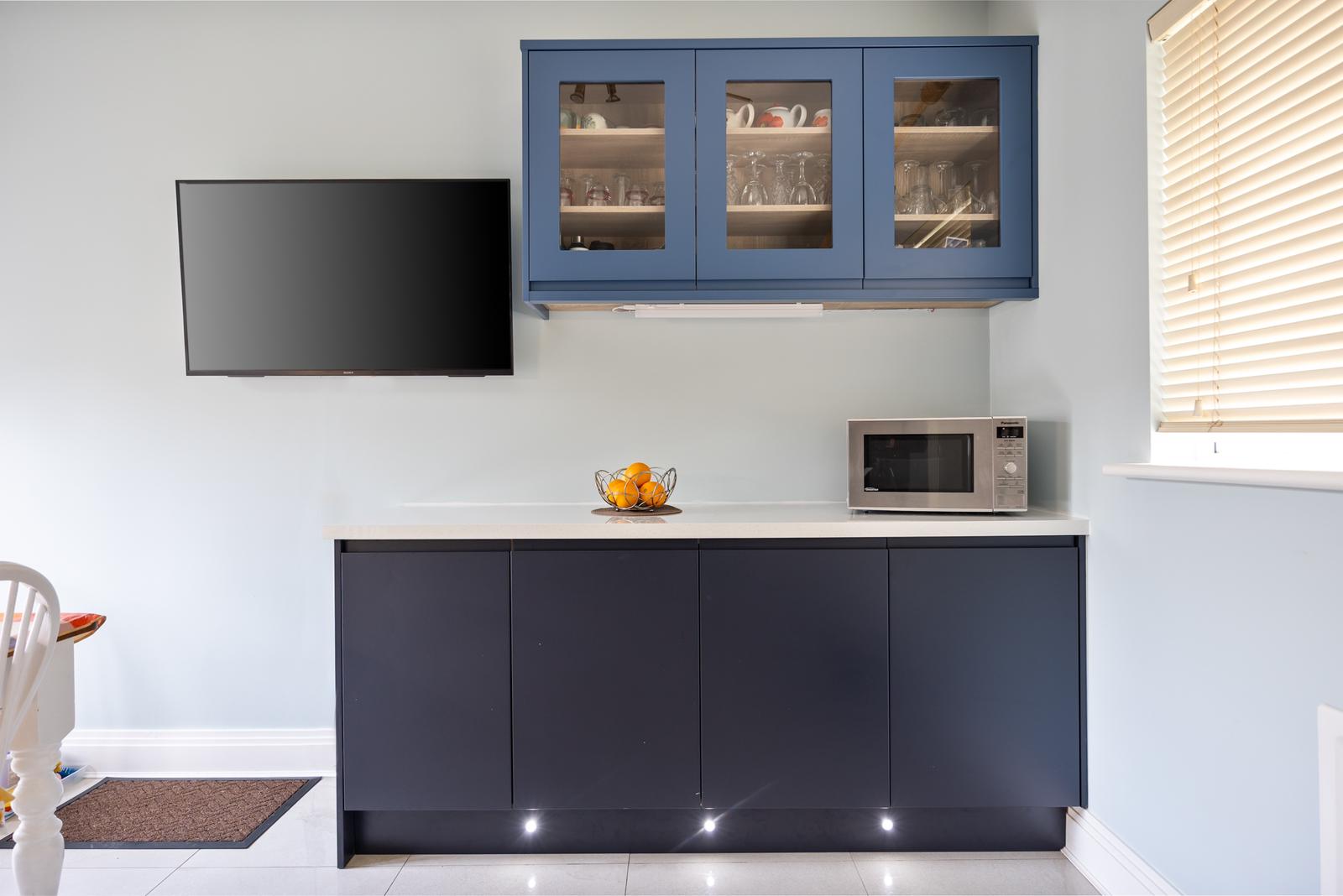 Modern bathroom featuring wooden cabinetry, a bathtub, a sleek sink, and natural light from a window.