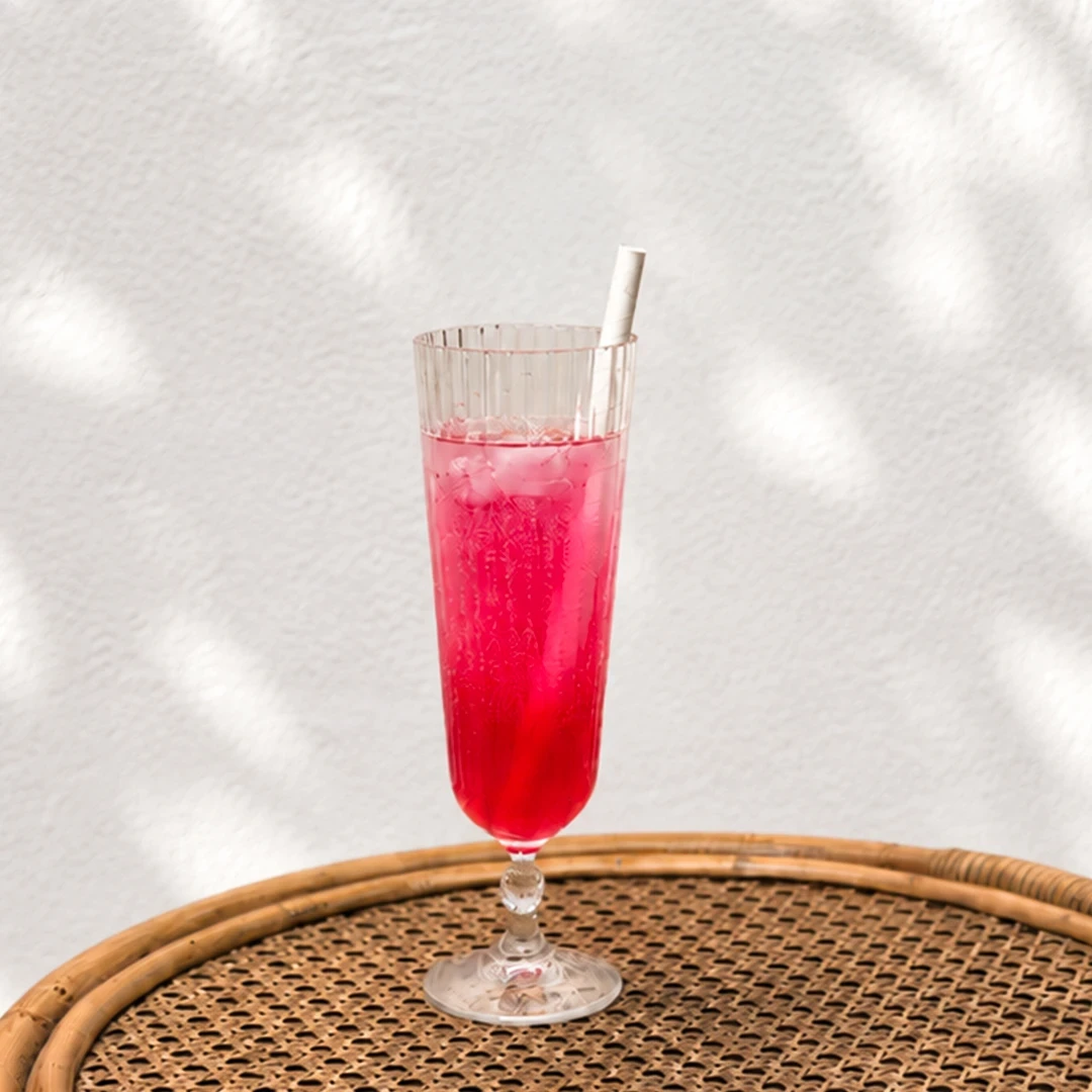 Pink lady With ice and a straw in a glass