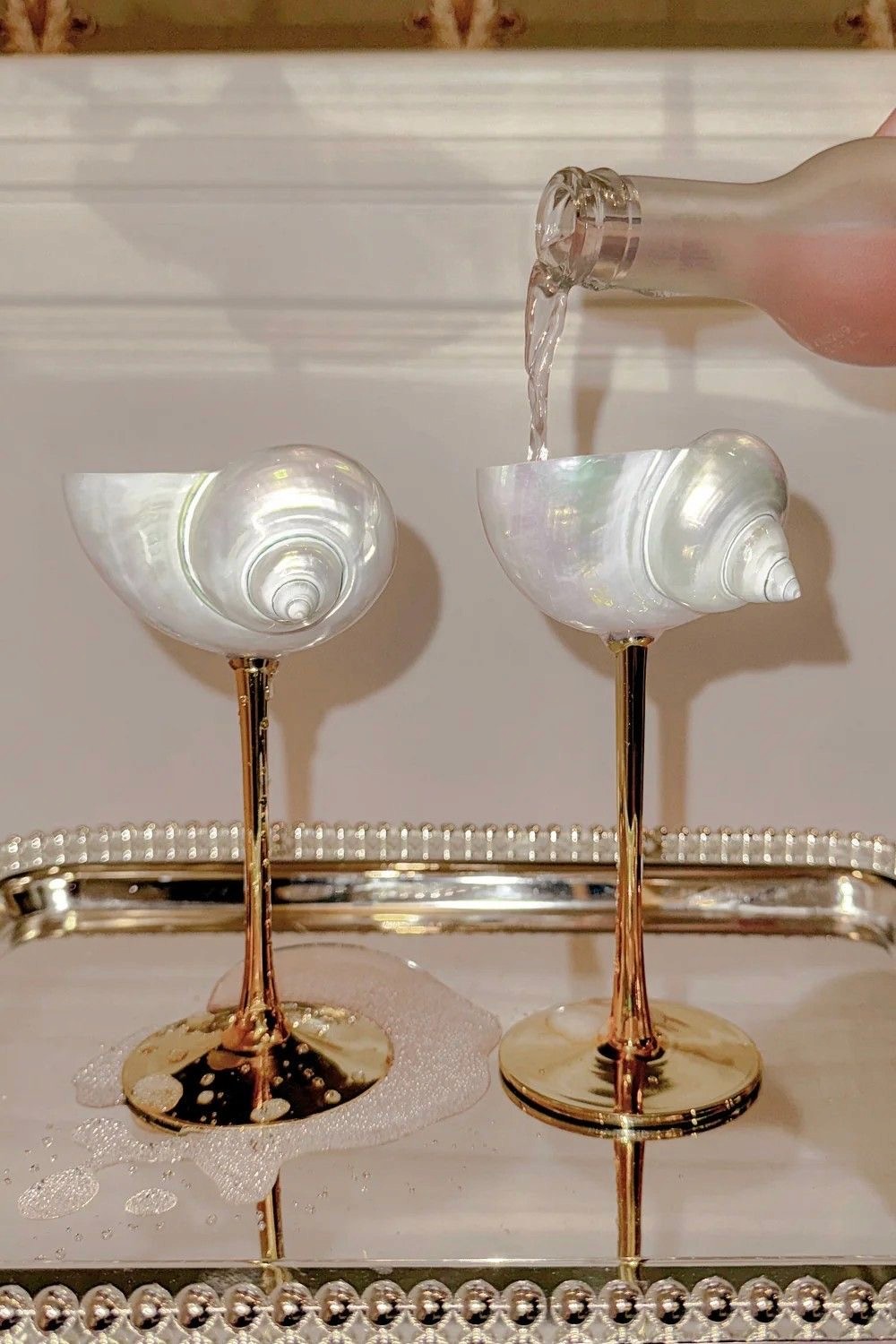 A beautifully set dining table with white tablecloth, cutlery, and fresh greenery in a cozy, well-lit space.