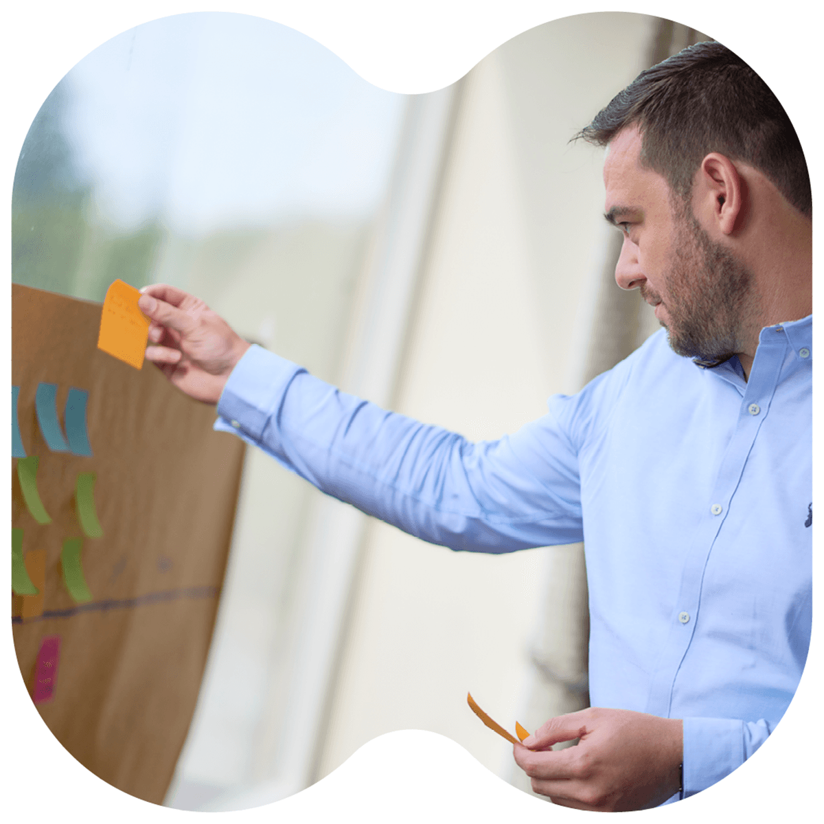Photo of an Opencast team member placing a post it on a board
