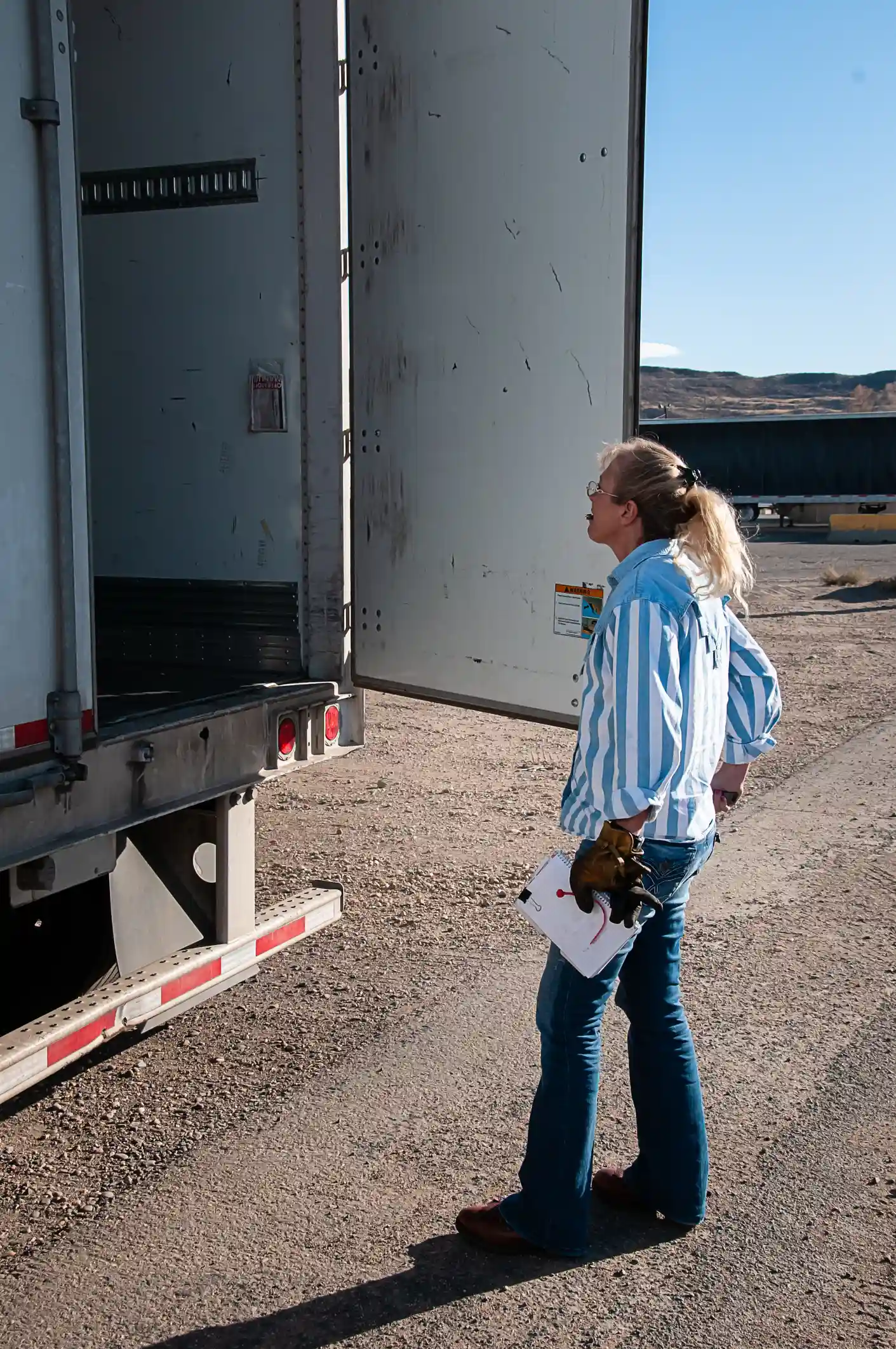 Truck driver inspecting truck trailer illustrating motor truck cargo coverage by Reliable Transportation Association