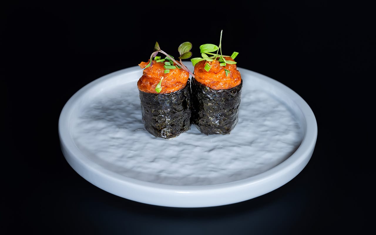 A close up of a sushi with chopsticks