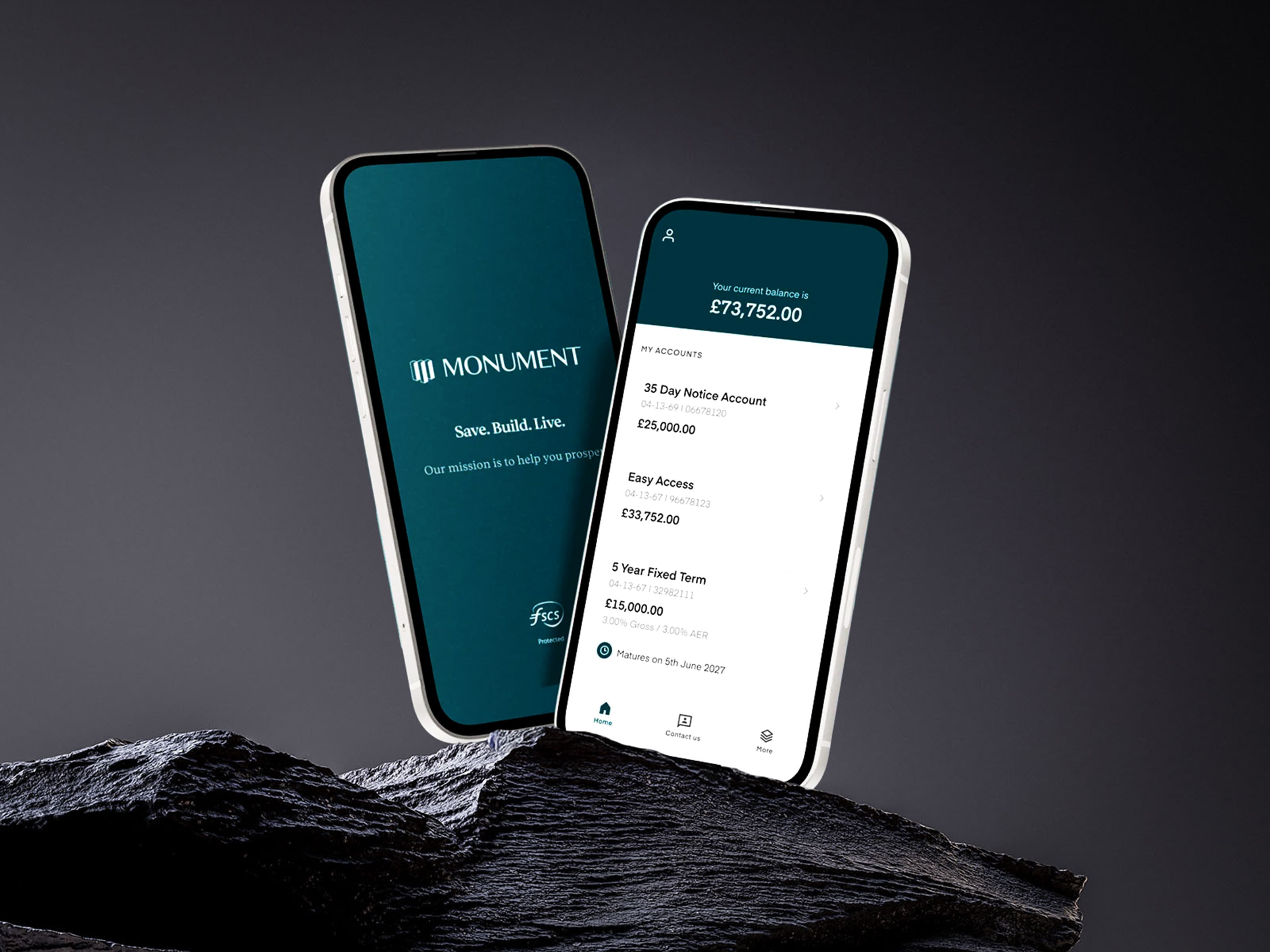 Monument Bank mobile app dashboard displayed on two iPhones resting on a dark stone texture, emphasizing the architectural design language.