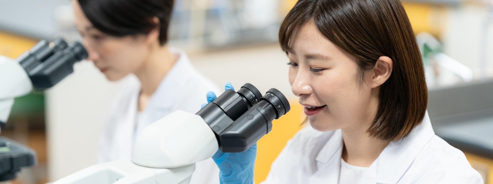 女性が顕微鏡を見る様子