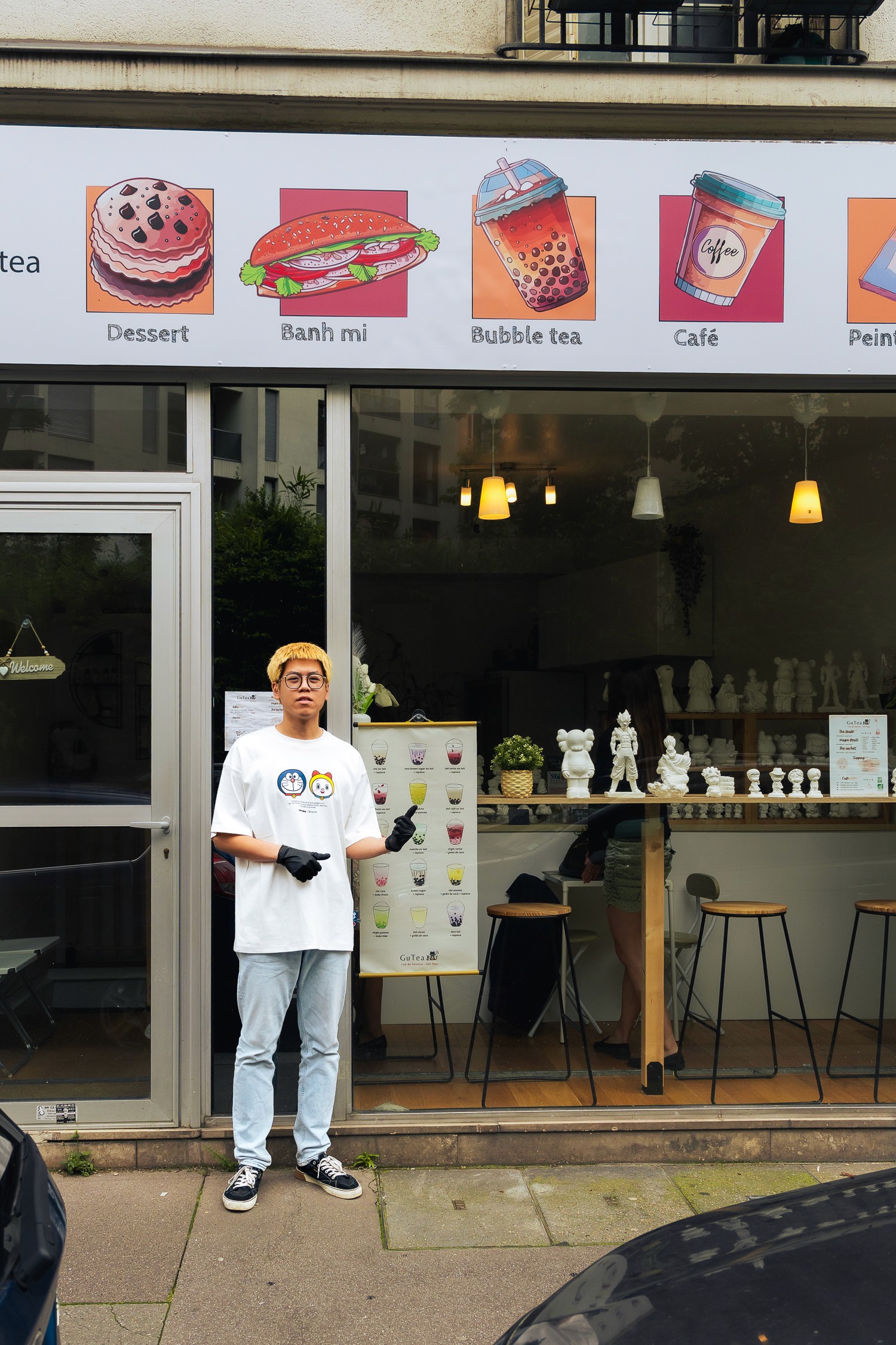 Patron devant l'enseigne de GUTEA Paris 13e, spécialisé en bubble tea.