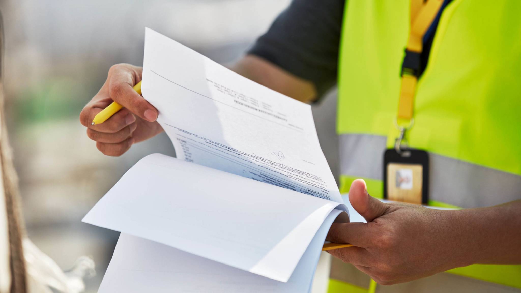 Customs officer in a high-visibility vest reviewing import documentation and invoices