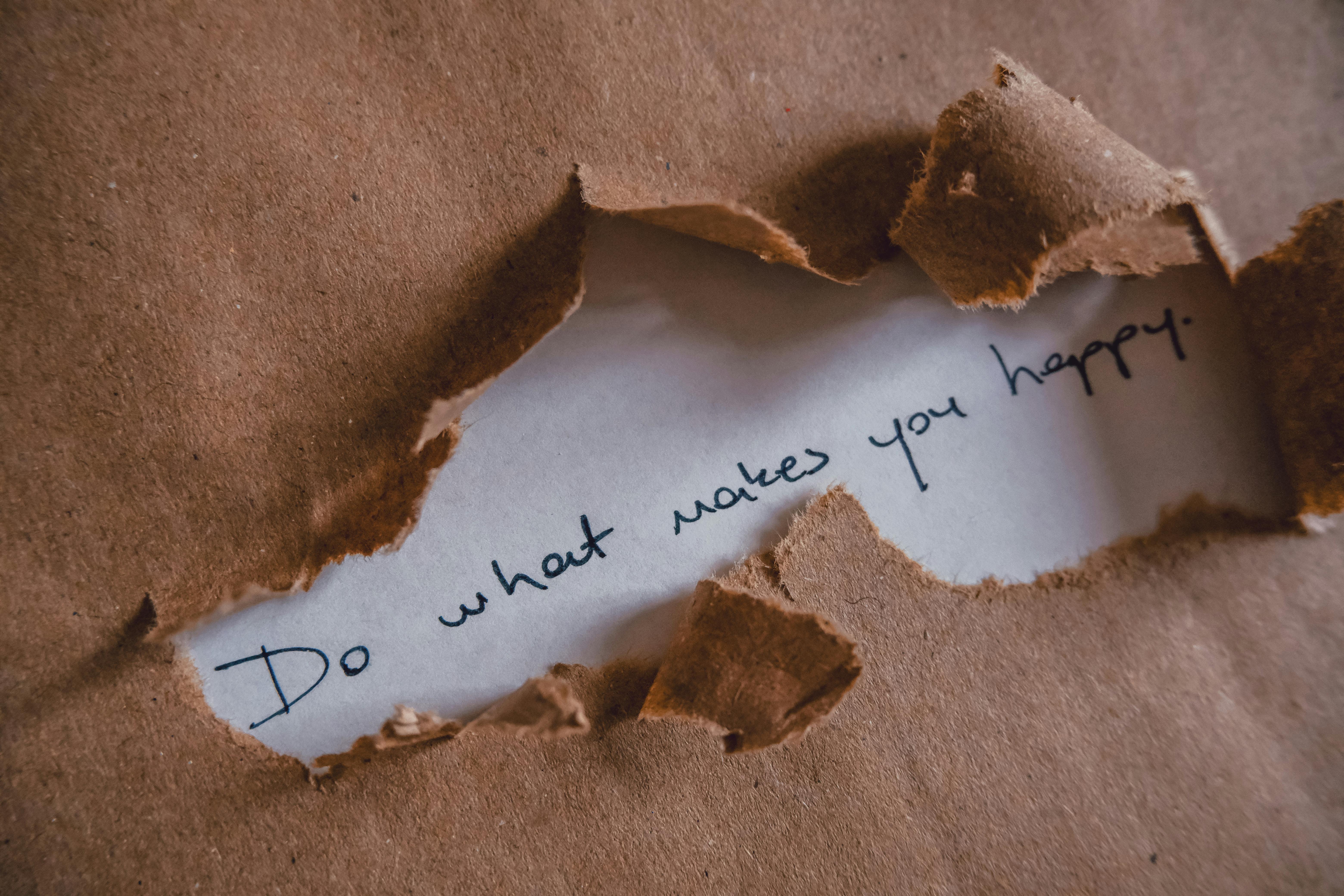 Messaggio scritto su carta “Do what makes you happy”, simbolo del momento di svolta e della presa di consapevolezza che porta un professionista over 30 a ripensare la propria carriera.