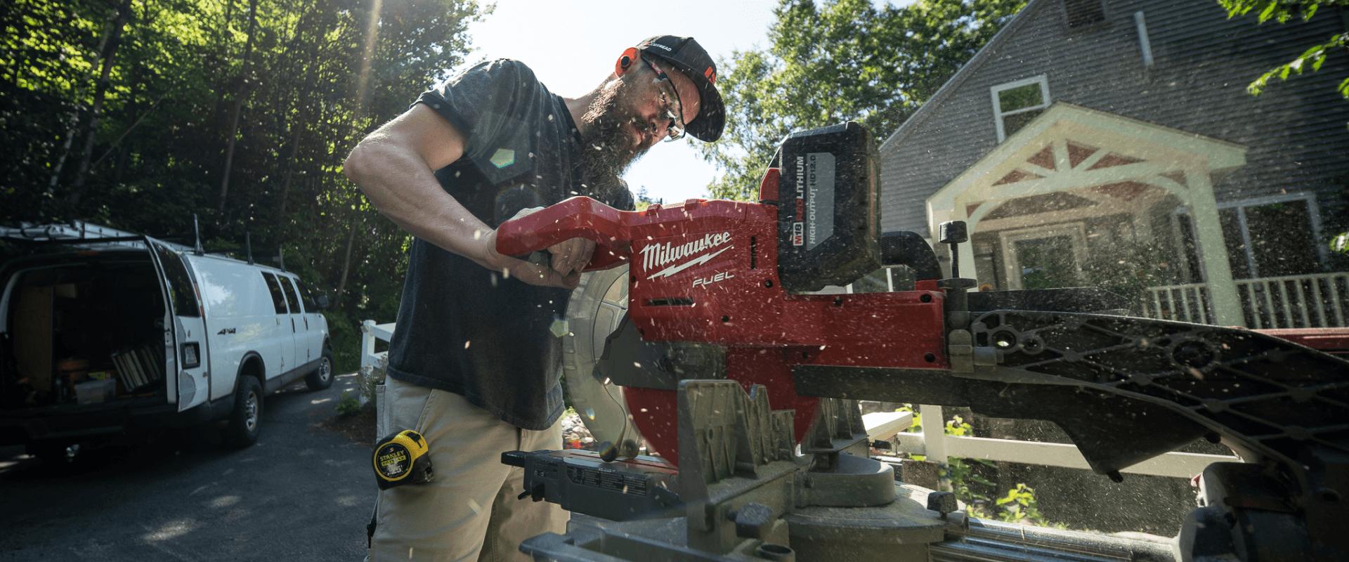 Owner Aaron using a chop saw to cut wood at a job site