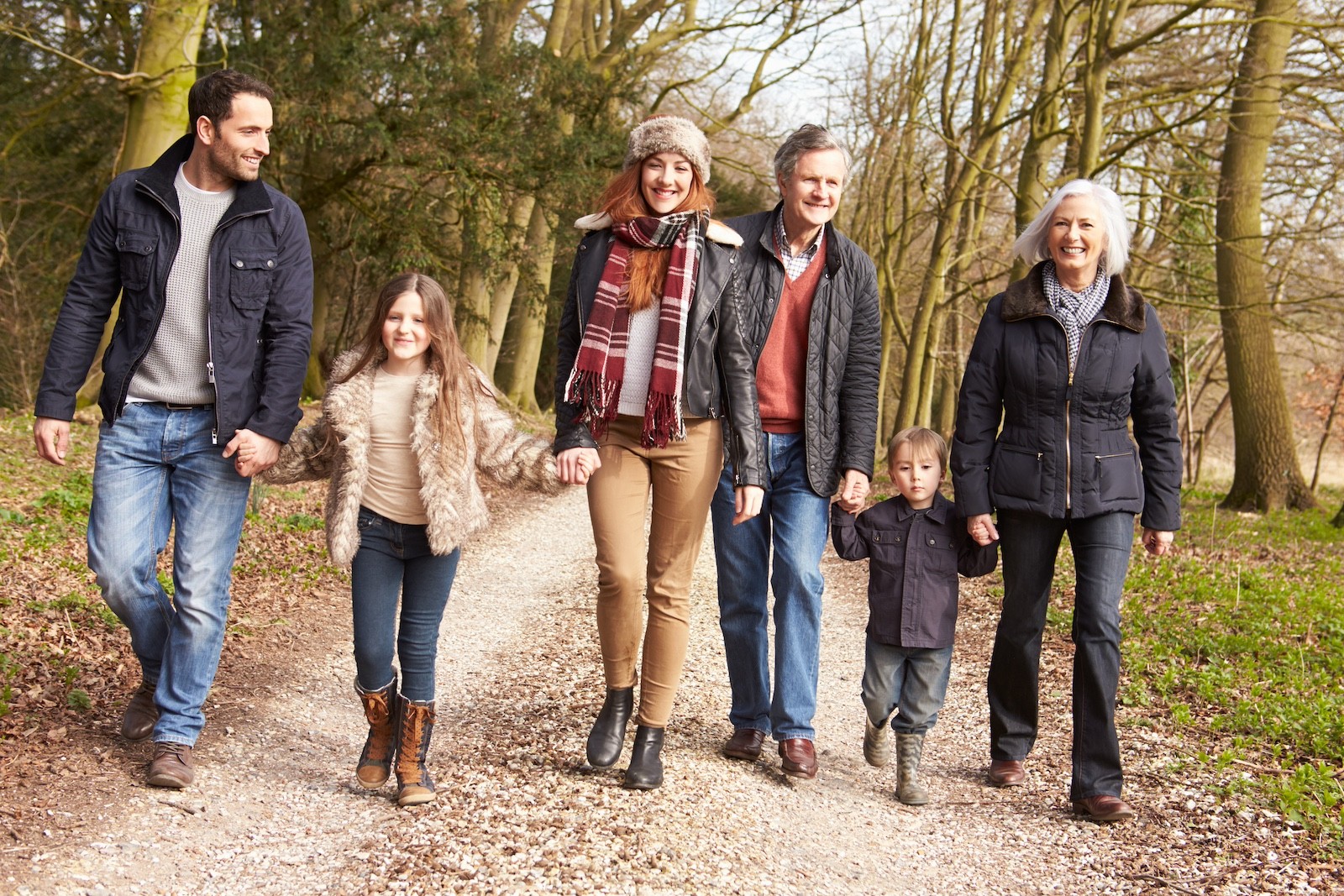 Multi-generation family walking together in the countryside, reflecting long-term stewardship, family trusts, and generational planning for wealthy families