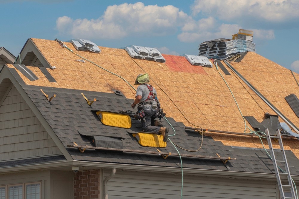 Roofers completely replace old asphalt shingle roof during summer in Canada