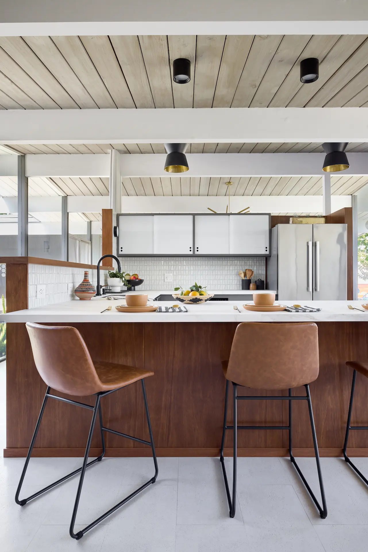 Portrait view of the bar seating area of the kitchen countertop, emphasizing the seating arrangement and countertop details in the Fairhaven Eichler Tract remodel. Photo by Todd Huge.