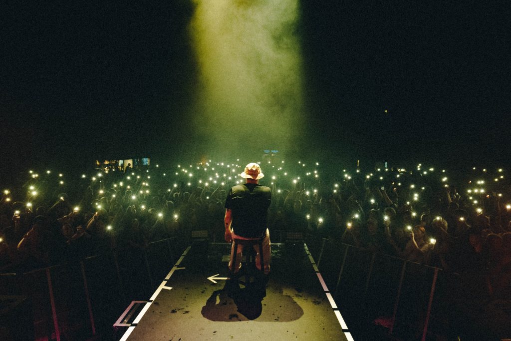 Four diverse professionals collaboratively working on a laptop, with one person pointing at the screen while others observe.