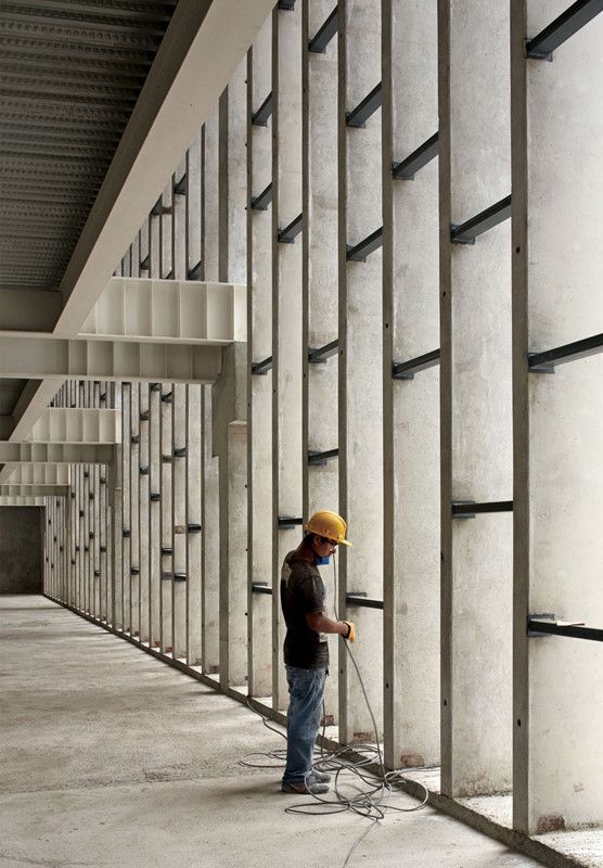 man kneeling on unfinished building during daytime