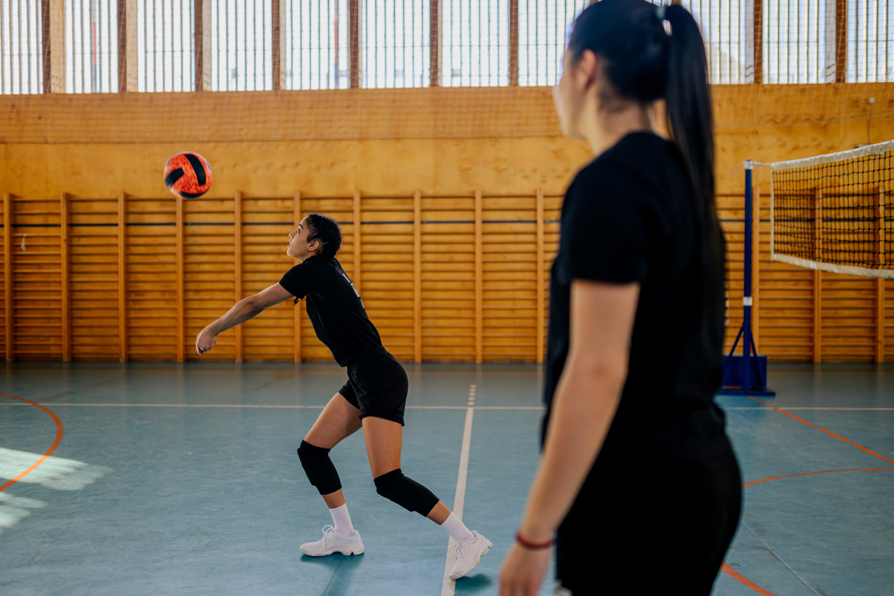 Girls playing a volleyball match during a Pianeta Sports tour.