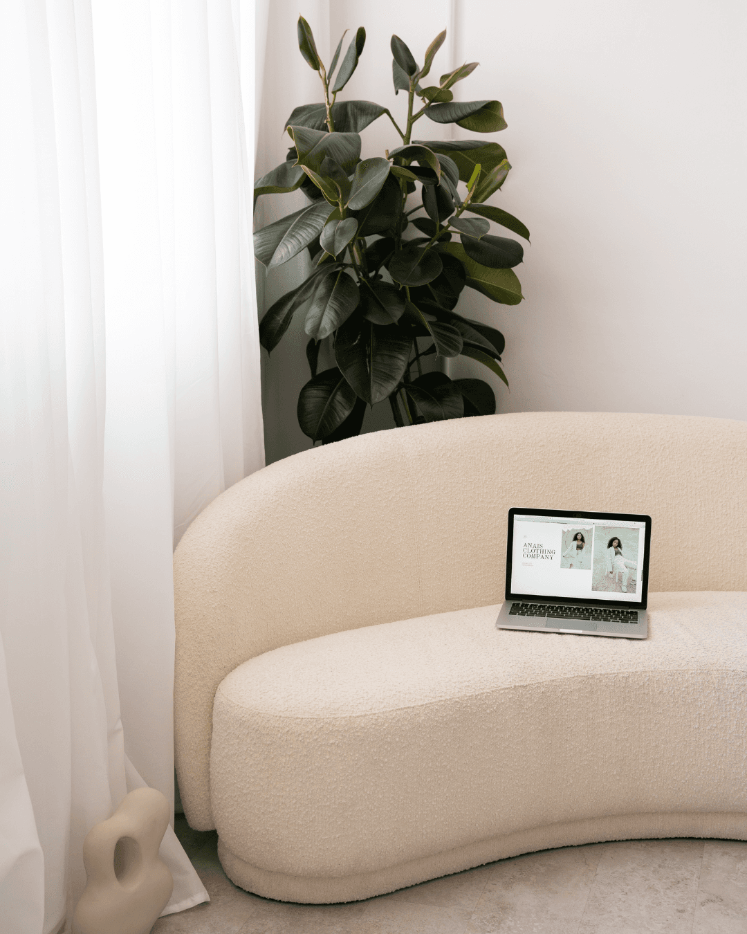 Ordenador sobre un sofá beige con una imagen de una web