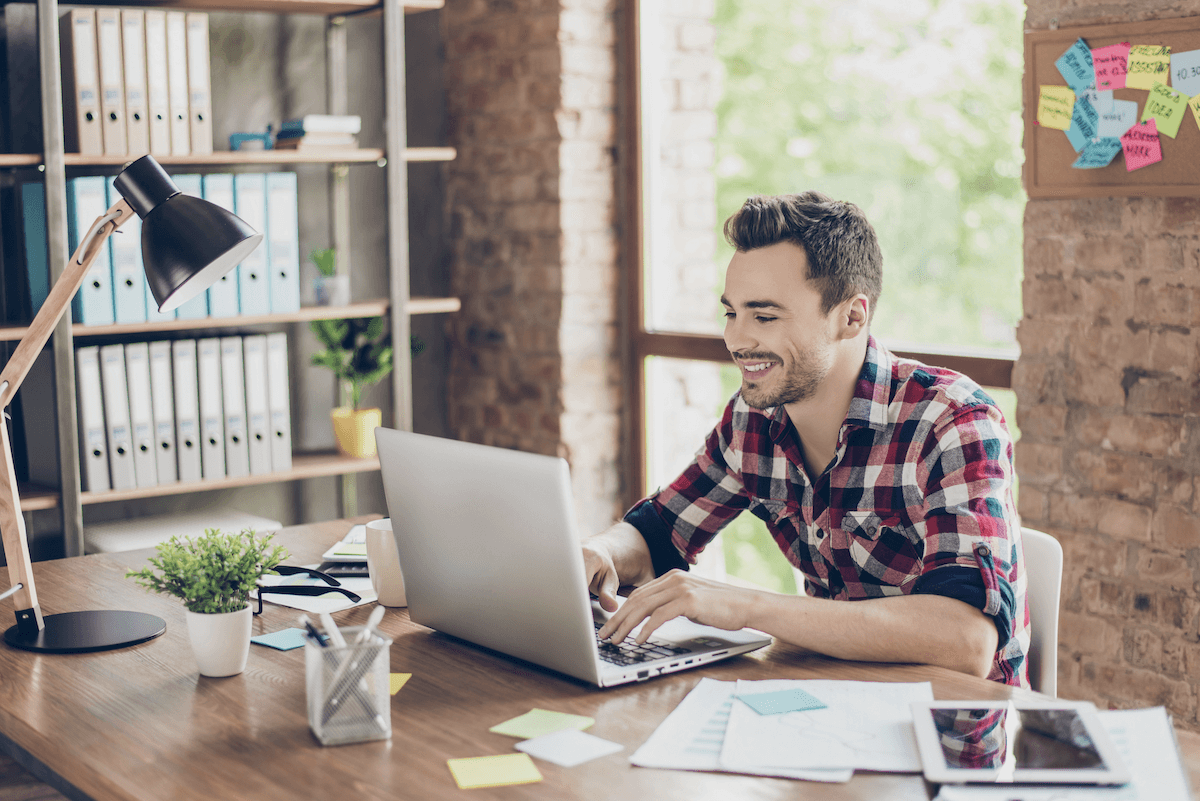 customer engagement software: Smiling man using his laptop