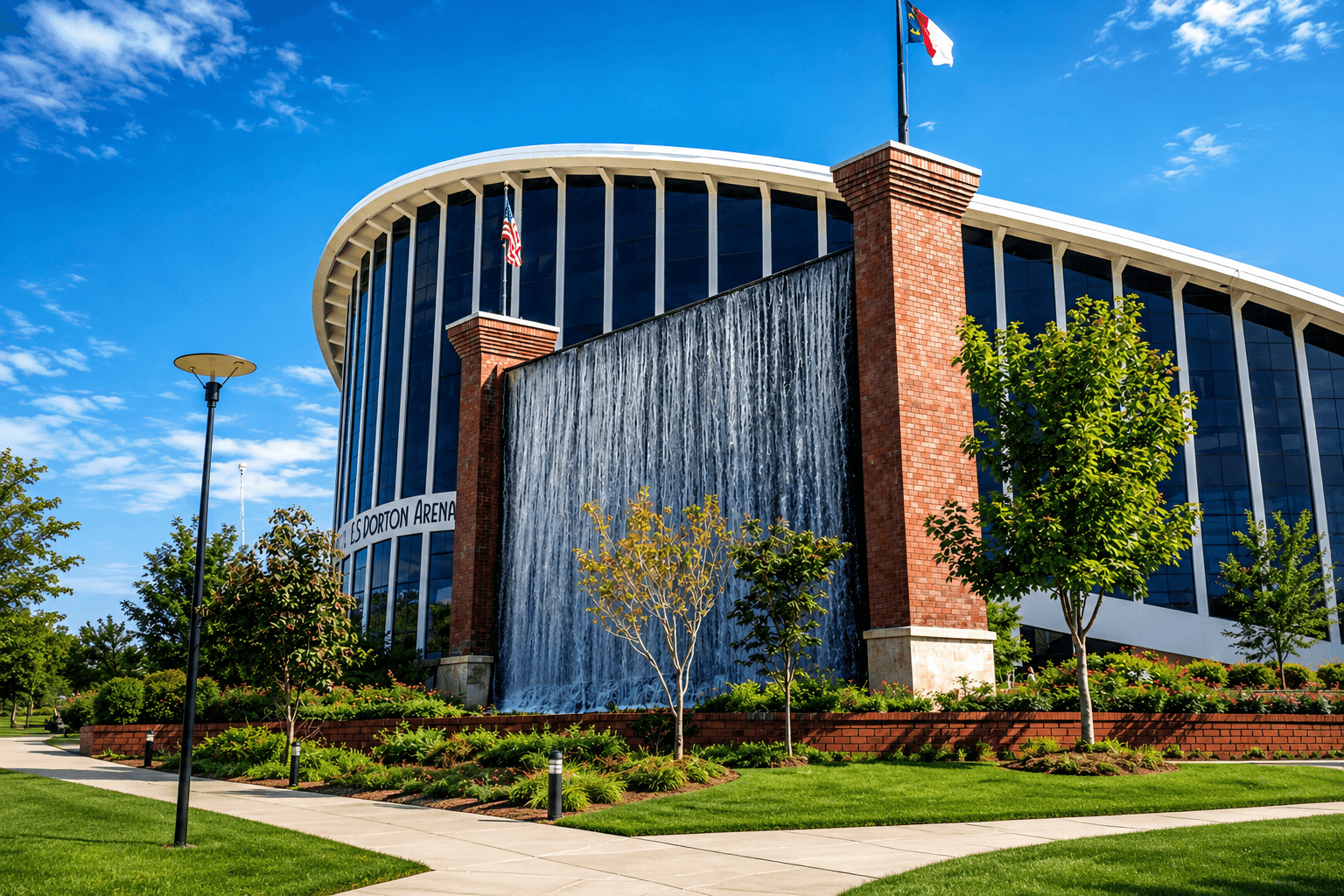 J.S. Dorton Arena waterfall wall in Raleigh, North Carolina, featuring a custom concrete water feature beside the arena’s curved exterior and landscaped grounds.